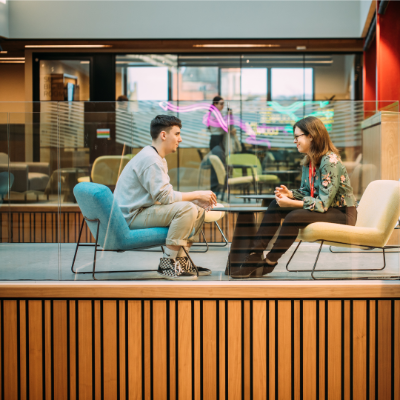 Male student sitting having a one to one interview with a female staff member in One Elmwood