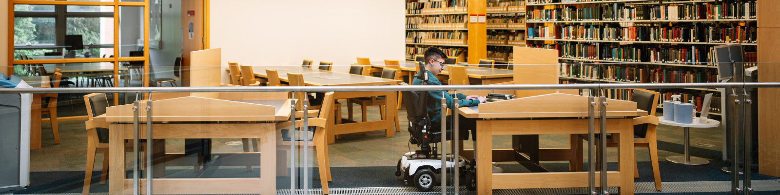 A student in a wheelchair studying in the McClay Library