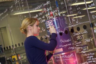 Researcher writing on glass board