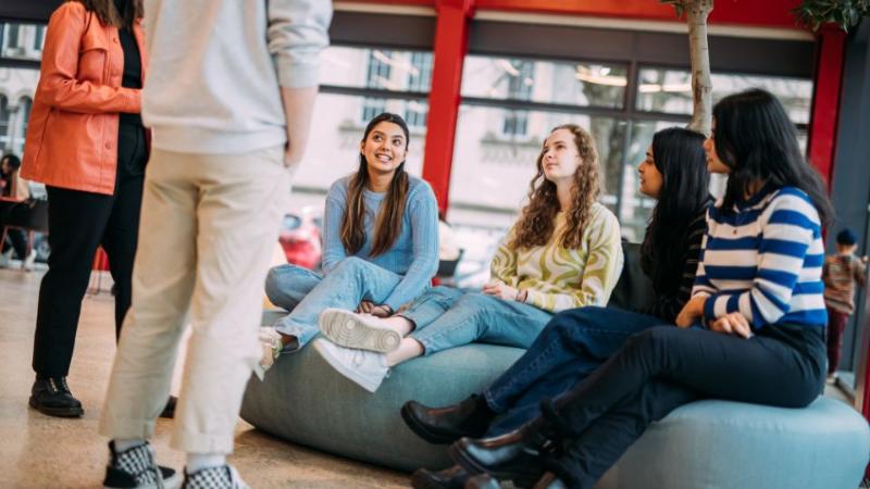 students sitting on seats in student centre chatting