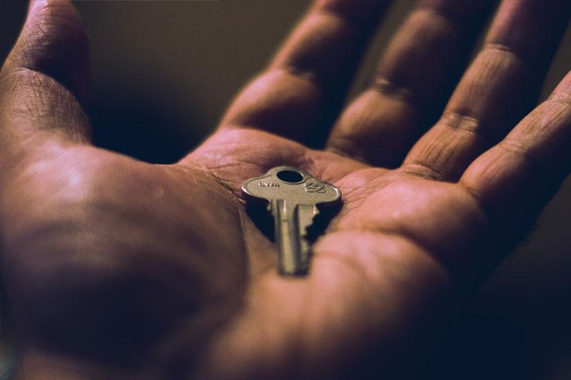 An open hand with a gold key in the centre of the palm