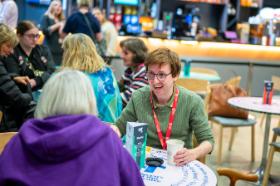 Male Staff member talking with animatedly to a member of Adapt NI