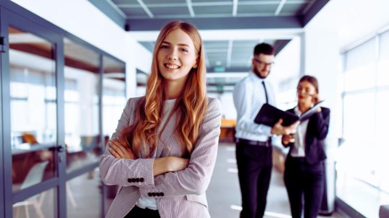 young female standing smiling to camera in an office environment