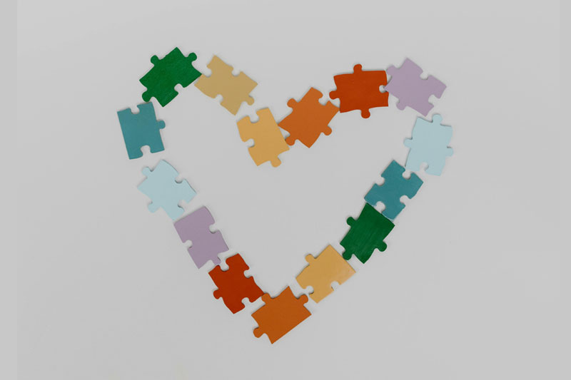 Jigsaw pieces of varying colours shaped into a heart symbol