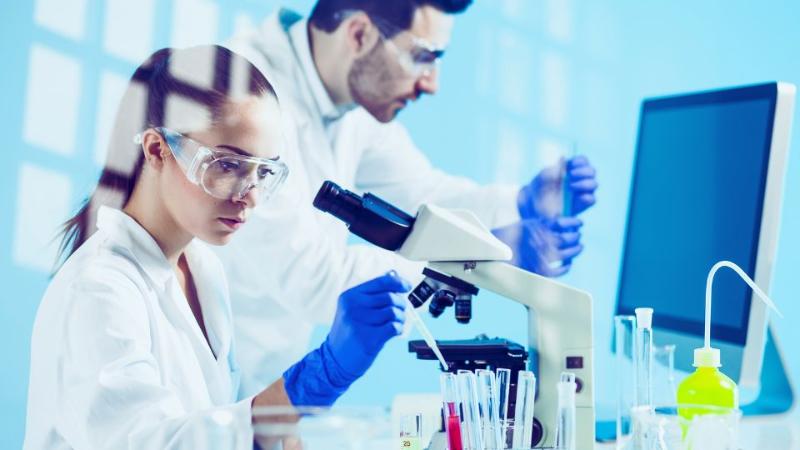 two scientists in a lab using lab equipment