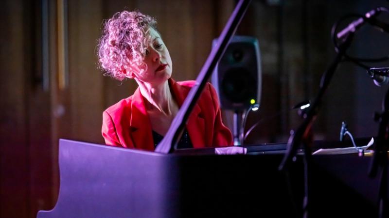 Person sitting at and playing a piano