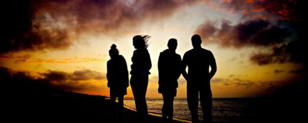 silhouettes of 4 people on the beach