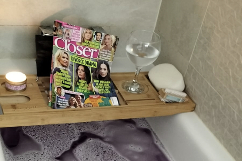 Magazine and glass of wine on top of a bath