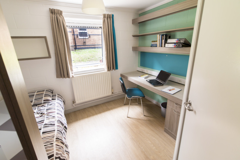 A students room in Elm's Village student accommodation, including a bed and work area