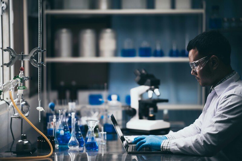 Researcher looking at laptop in lab