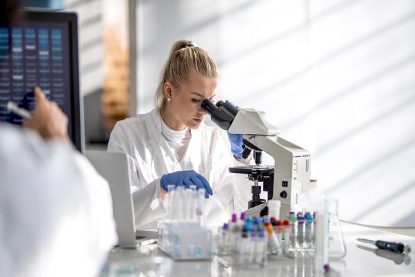 Cancer researcher looking through microscope