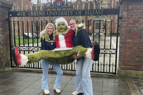 Two students pose with the Grinch outside the Lanyon gates