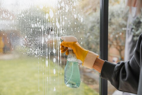 Person spraying window with window spray