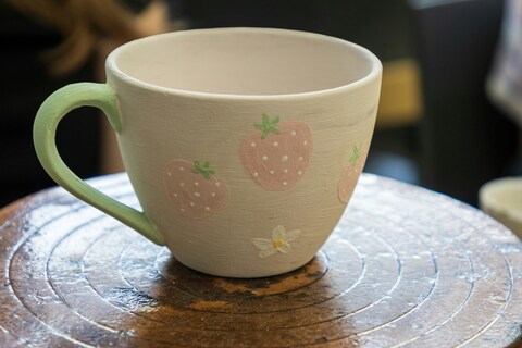 White mug painted with strawberries