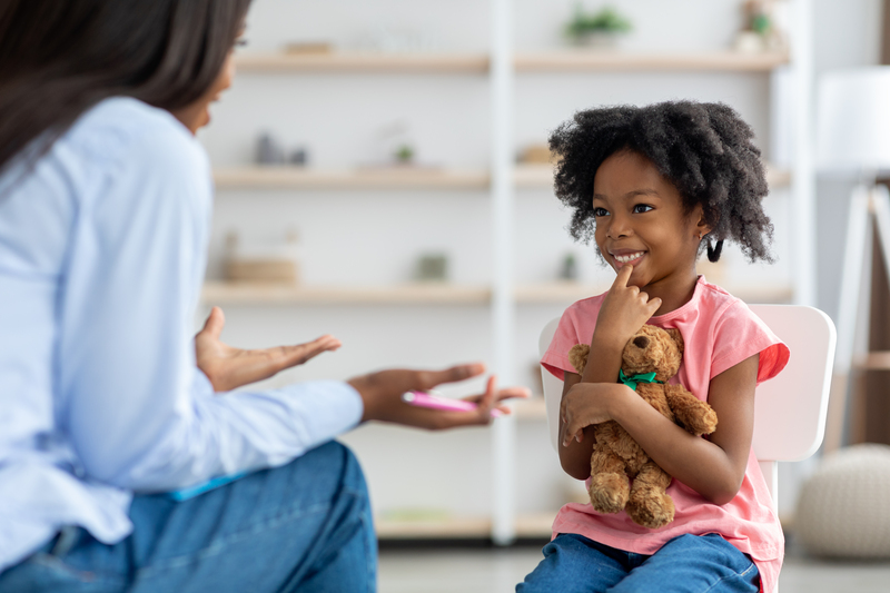 Girl holding teddy bear in psychologist's office