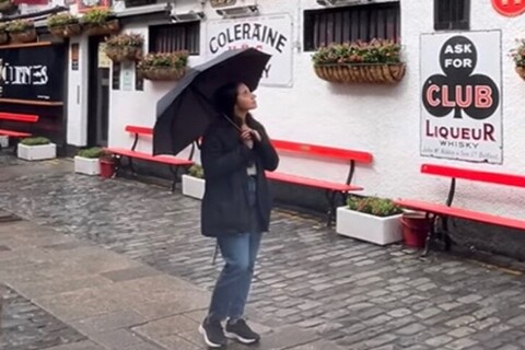 Student Isa walks the streets of Belfast with an umbrella