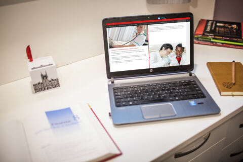 Laptop and book on table in accommodation