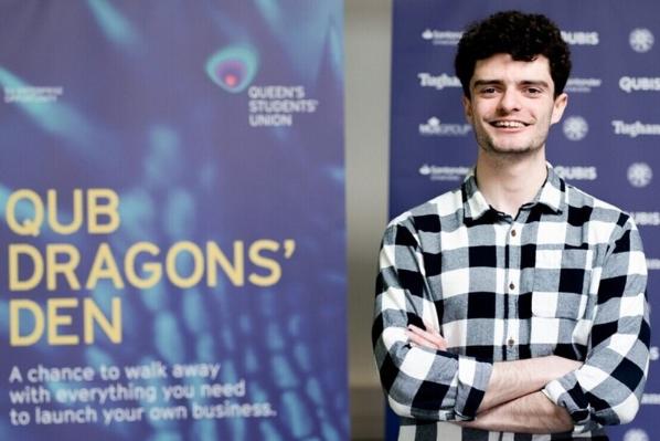 Liam Maguire in front of QUB Dragon's Den banner