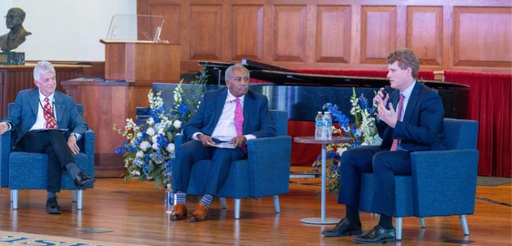 Three people sitting on a stage.