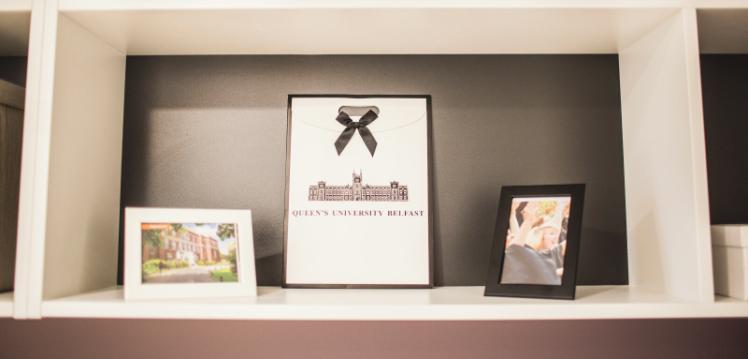 Three framed pictures on shelf