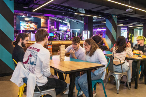 Group of students playing board game in gaming cafe