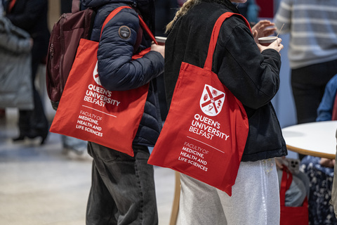 Two students holding MHLS tote bags