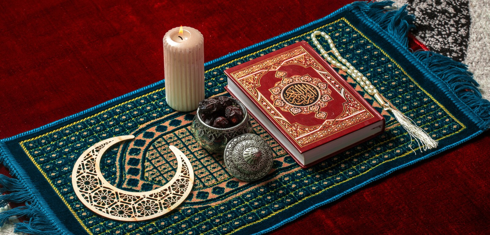 Prayer mat, candle, snacks and book for Ramadan