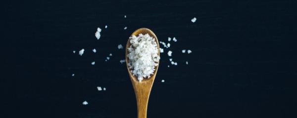 Salt on a spoon with dark blue background