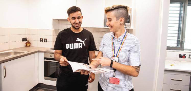 Student moving in to Queen's accommodation and receiving instructions from staff