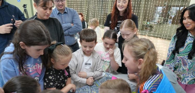 A group of children and adults gathered around a street map