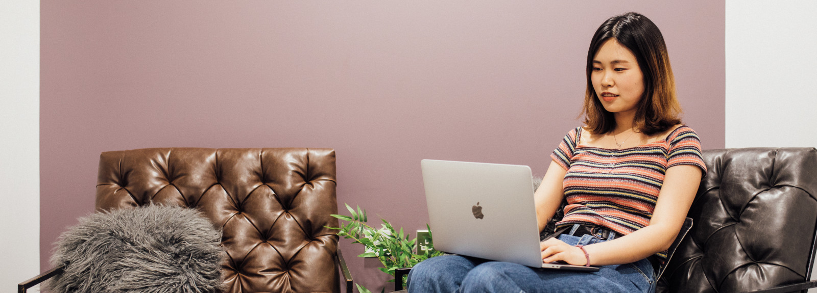 Student typing on laptop on sofa