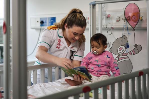 Nursing student with female baby in hospital style setting