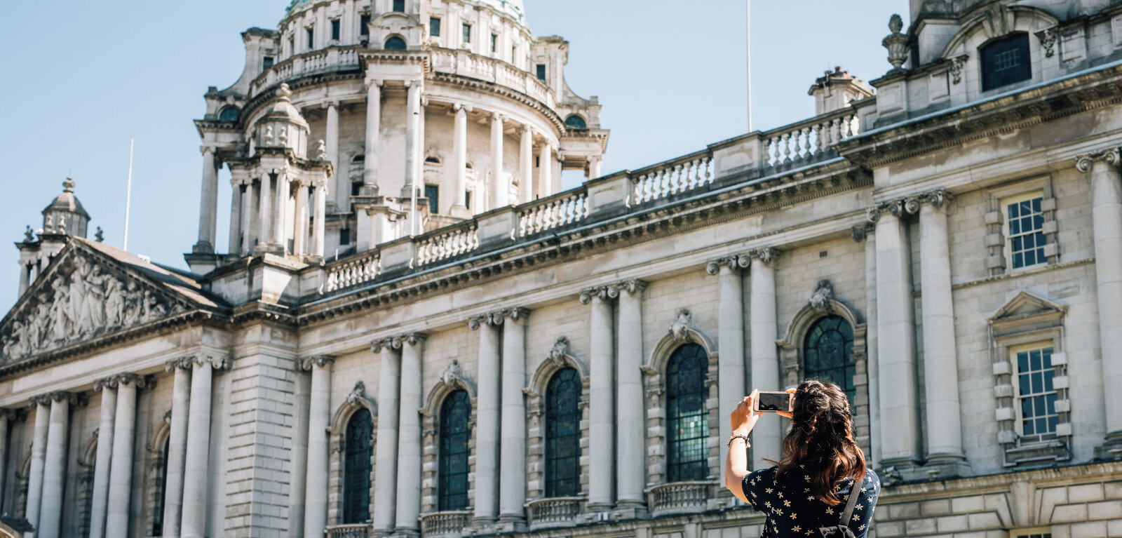 Female student taking a photo of Belfast city hall