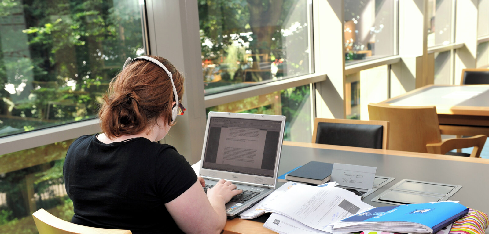 Student typing on laptop in the McClay Library