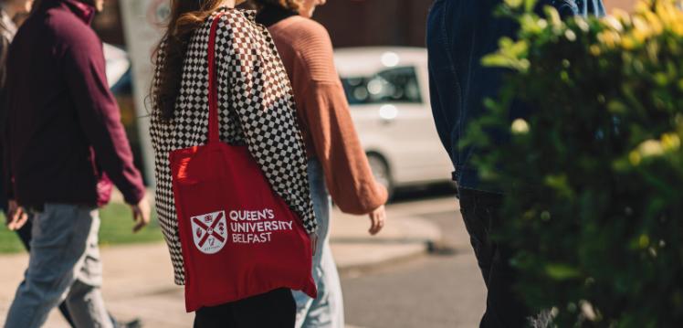 Student walking with QUB tote bag