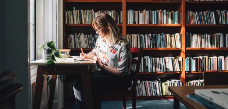 Student writing at desk