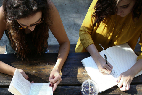 Two students writing in notebooks