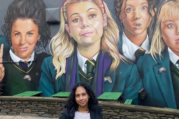 Student Sumita in front of Derry Girls mural