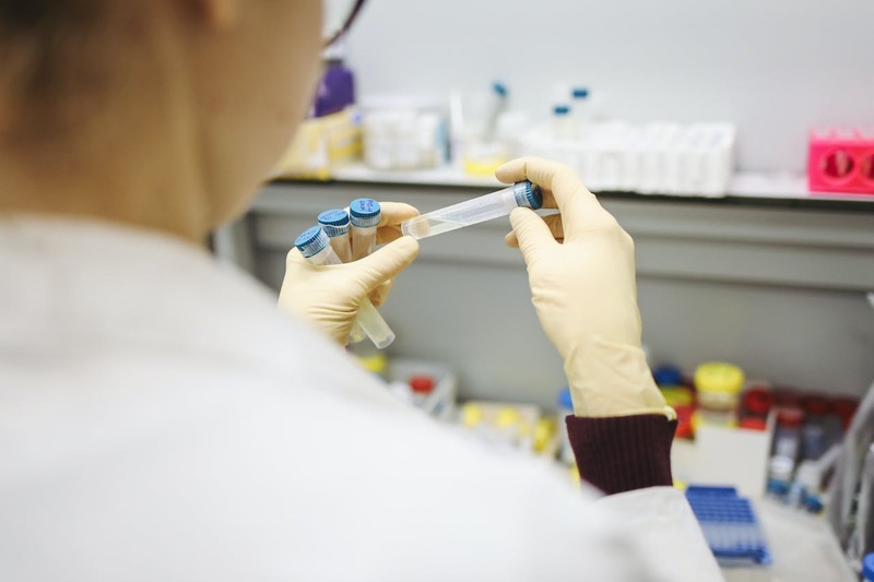 Person holding test tubes