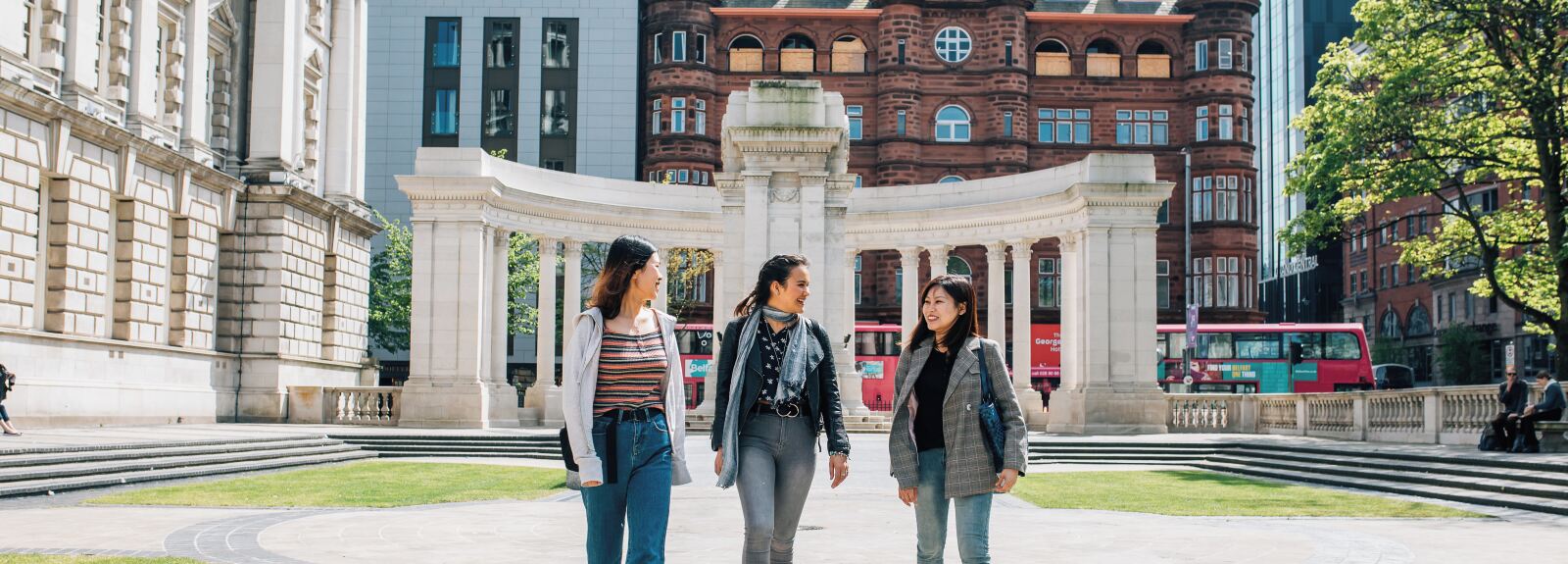 Three students walking at the side of Belfast City Hall