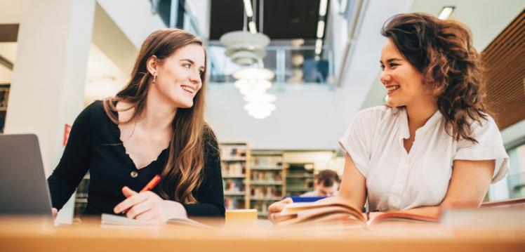 Two students sitting at table in McClay Library