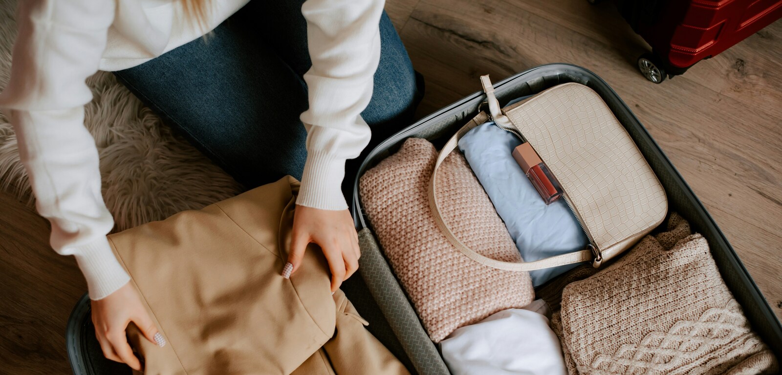 Woman packing suitcase with clothes