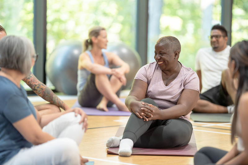 Group of people sitting on yoga mats