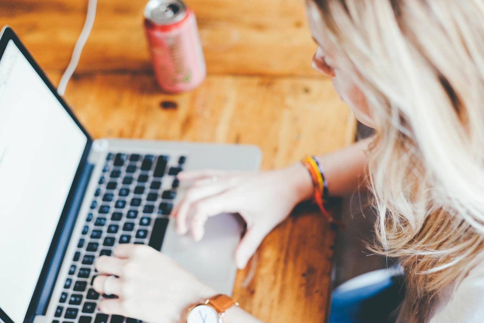 A female student types on the keyboard of a Macbook computer