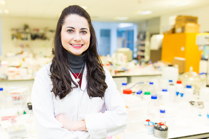 Image of a PhD student standing in a laboratory