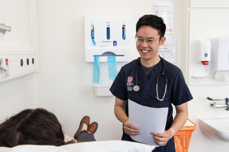 A Queen's medical student working with a patient