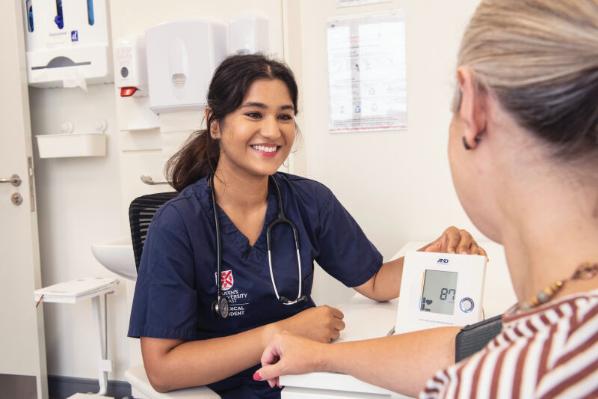 A Queen's medical student working with a patient