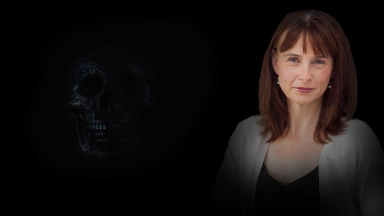 Smiling woman on a dark background with a black calaveras emerging from the shadows