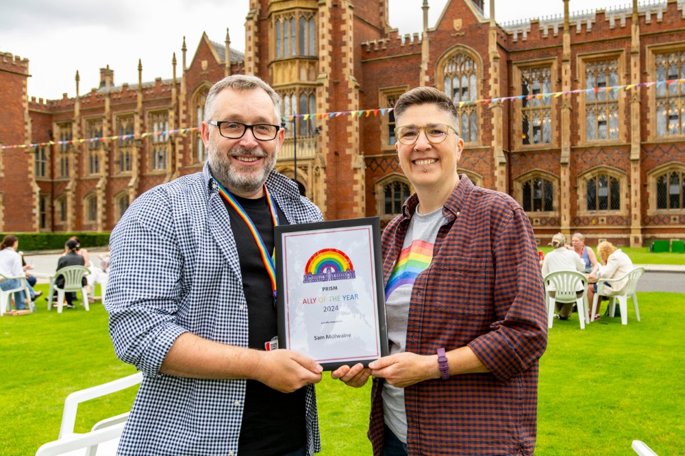 Sam McIlwaine receiving his 'Ally of the Year' award from PRISM LGBT+ Staff Network Co-Chair Sally Bridge at Queen's Pride Picnic 2024